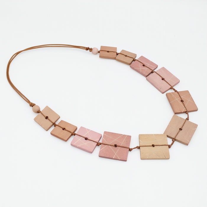 Necklace with square pink and beige beads on a white background