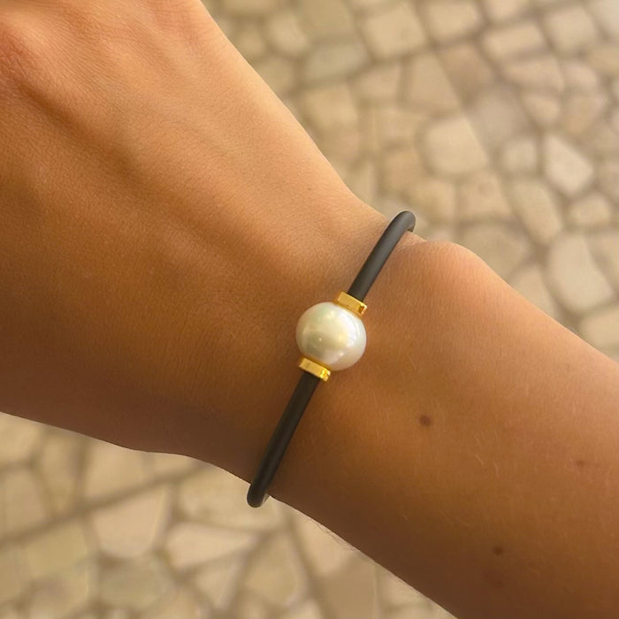 Black neoprene cord pearl bracelet worn on wrist – unisex coastal style