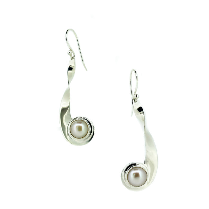 Silver earrings with pearl centers on a white background