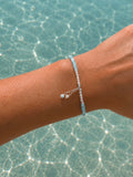 Light blue gemstone and freshwater pearl bracelet featuring delicate white pearls, soft blue beads and sterling silver accents on an adjustable design. A beach-inspired bracelet handcrafted for effortless coastal style.