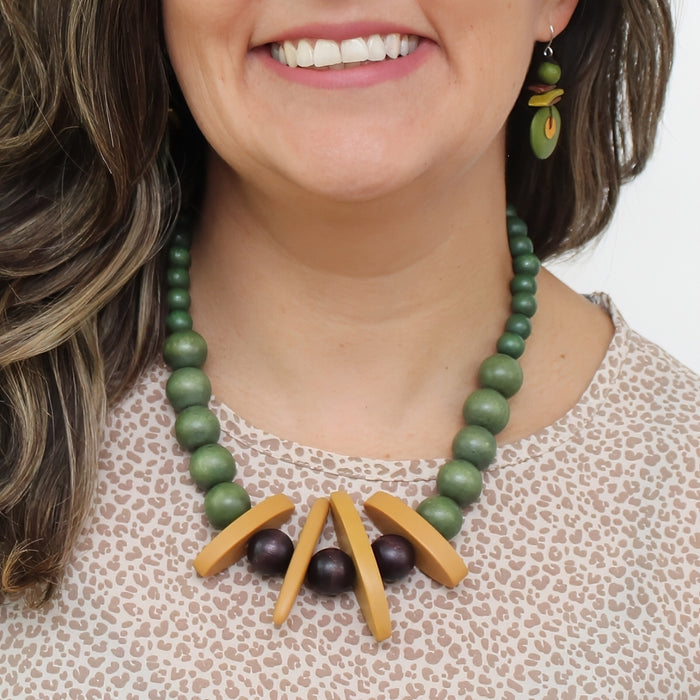 Model wearing olive green, mustard, and burgundy statement necklace