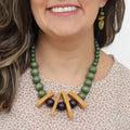Model wearing olive green, mustard, and burgundy statement necklace