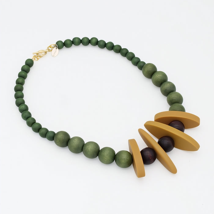 Angled view of olive green wood and mustard resin statement necklace