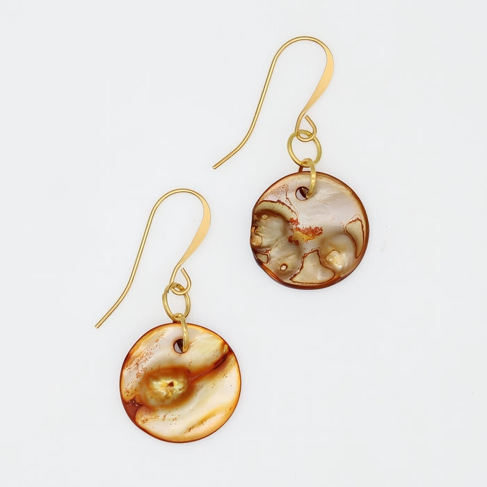 Pair of gold earrings with circular, marbled designs on a light gray background
