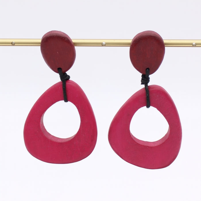 Pair of pink earrings with red tops on a white background