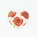 Heart-shaped brooch with floral design on a white background