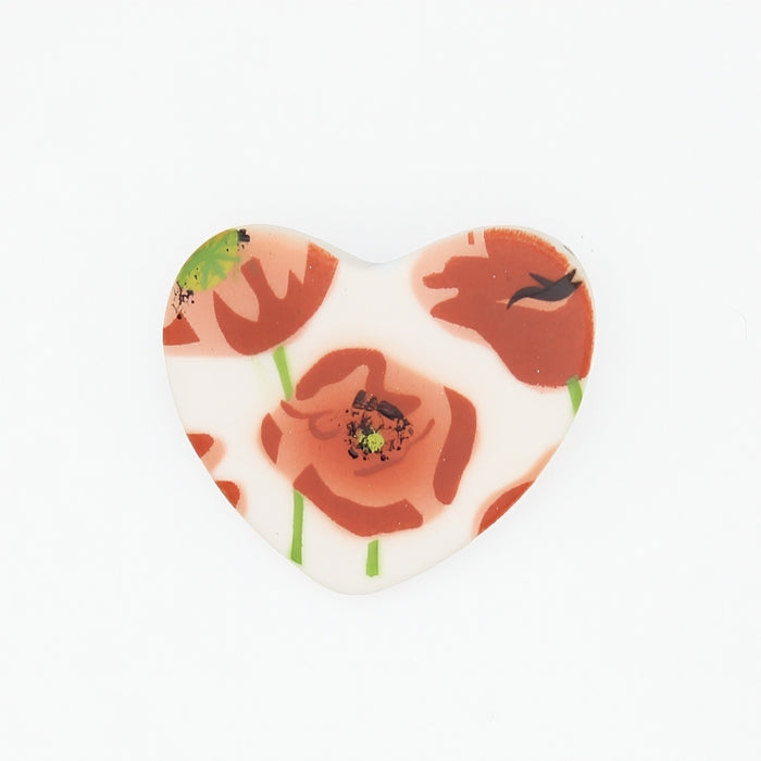 Heart-shaped brooch with floral design on a white background
