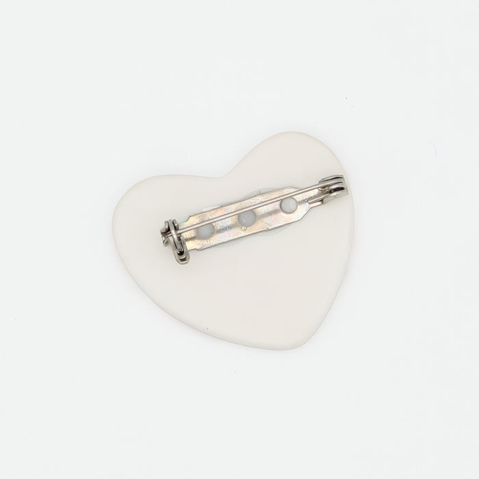 Heart-shaped brooch with a silver bar on a white background