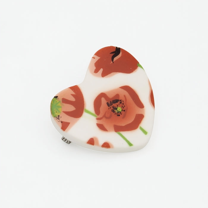 Heart-shaped pin with floral design on a white background