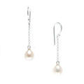 A pair of hook earrings featuring white pearls attached to silver chains.