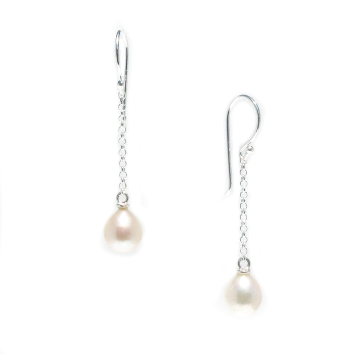 A pair of hook earrings featuring white pearls attached to silver chains.