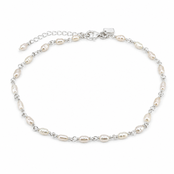 A silver chain anklet featuring irregular white freshwater pearls spaced along the chain, with a lobster clasp and extender chain
