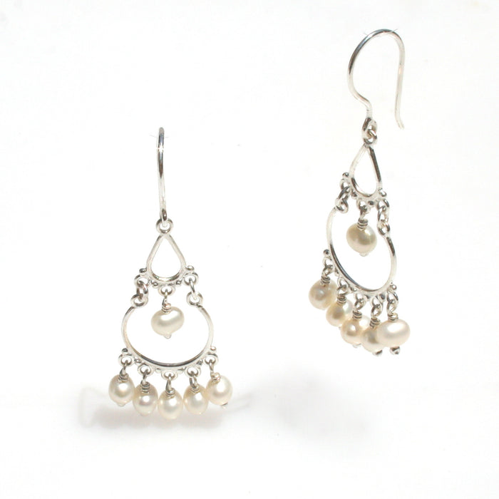 A pair of sterling silver earrings featuring seed pearls, with a boho design.