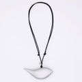 silver bird pendant on a black cord against a white background