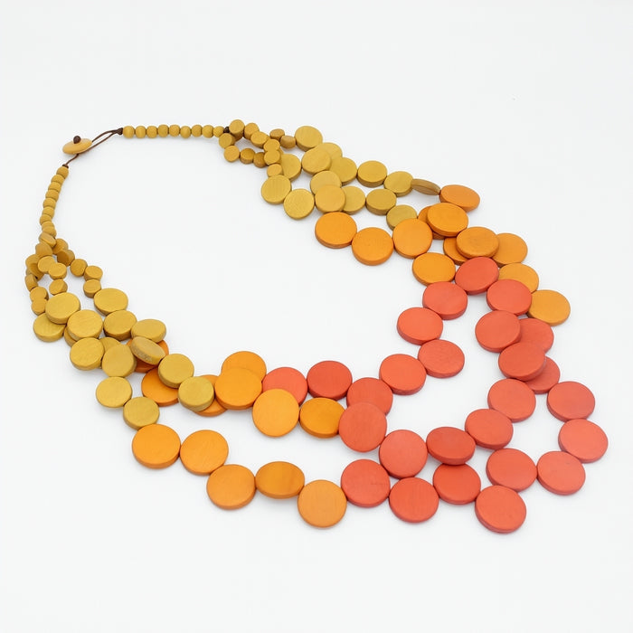 Necklace with orange and red disc beads on a white background