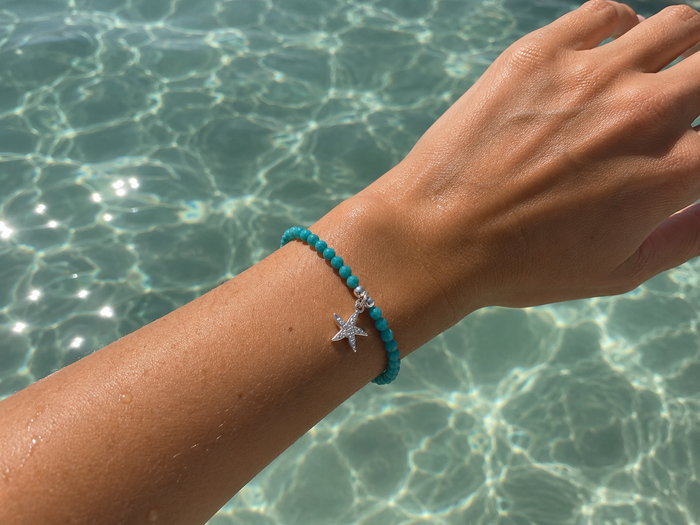 Ocean Spell Stretch Bracelet with turquoise gemstones and sterling silver starfish charm on a stretch bracelet design.