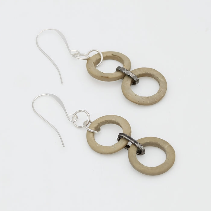 Pair of earrings with beige circular links on a white background
