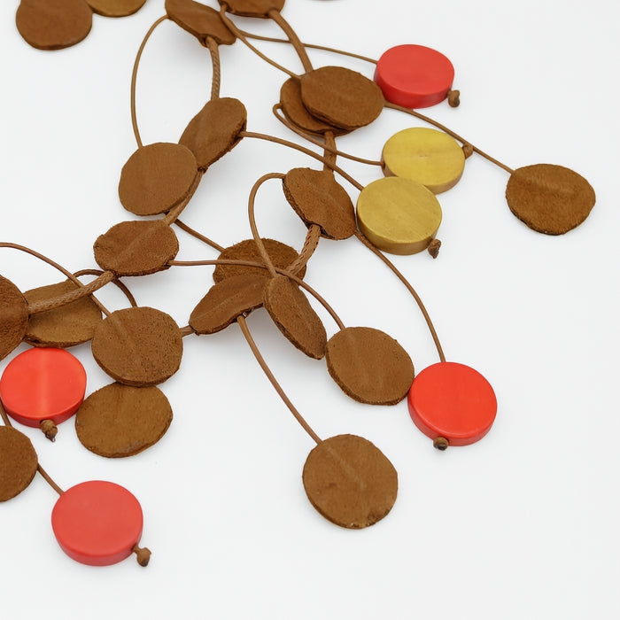 Decorative necklace with round wooden beads in brown, red, and yellow on a white background