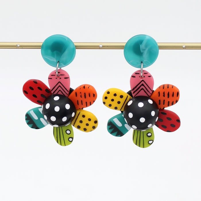 Colorful flower-shaped earrings with polka dot centers on a white background