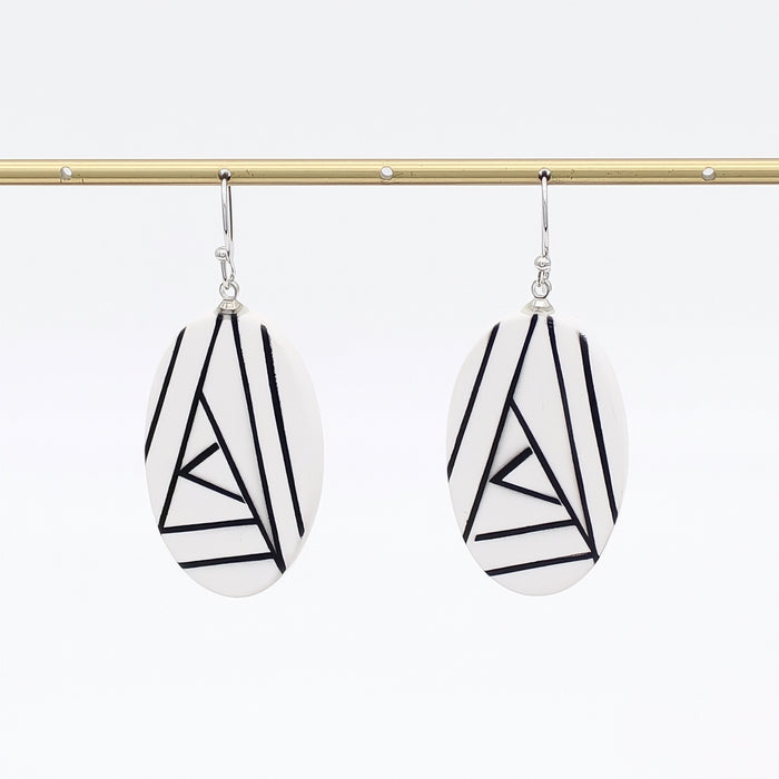 Pair of earrings with geometric black and white design on a white background