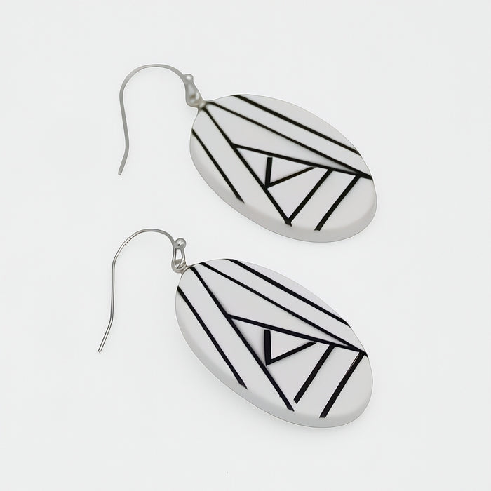 Pair of earrings with geometric black patterns on a white background