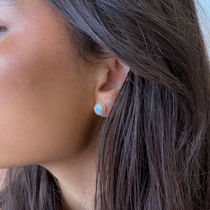 Close-up of an ear with a small earring, hair partially covering the face