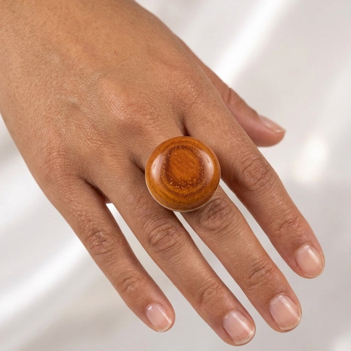 Wooden ring on a hand against a white background