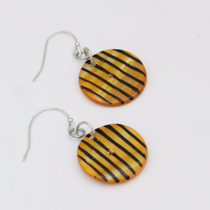 Yellow and black striped earrings on a white background