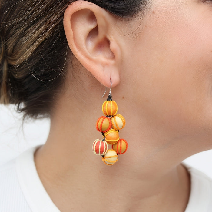 Close-up of a person wearing colorful beaded earrings.