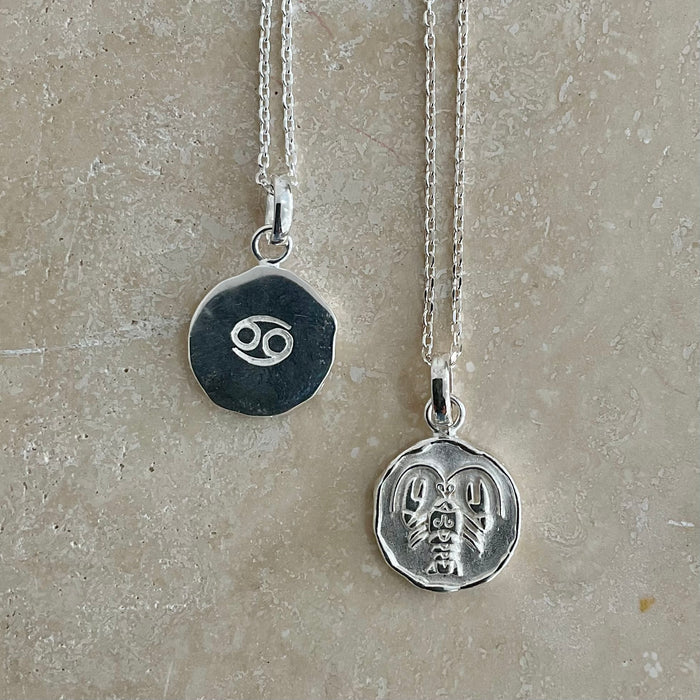 sterling silver necklaces with zodiac sign pendant, double sided one showcasing the Cancer symbol and the other with a dainty chain design, both on sterling silver pendant