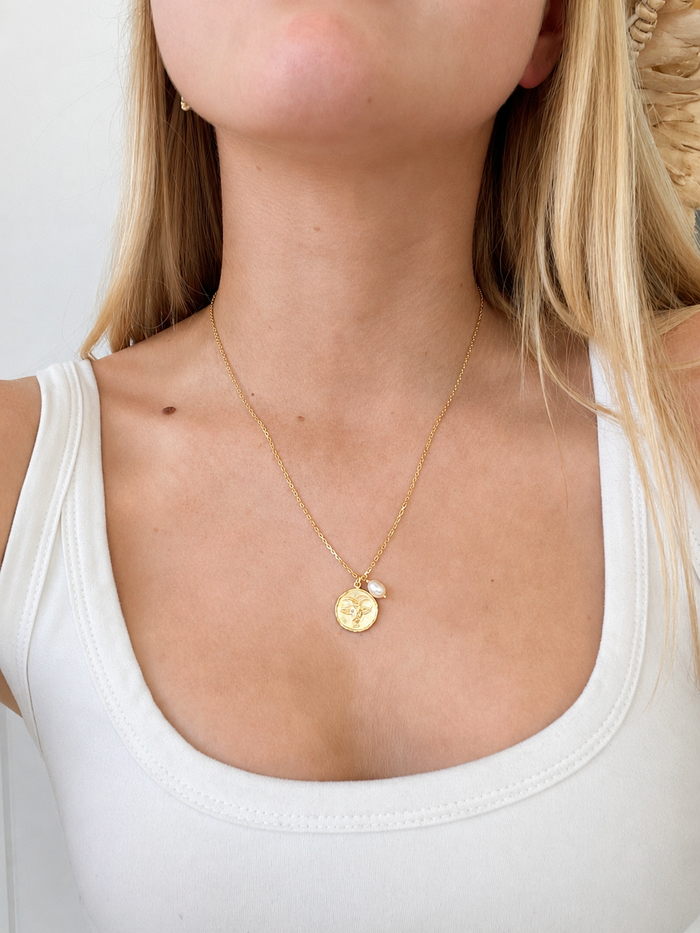 Zodiac Necklace Capricorn Gold in gold vermeil with Capricorn pendant and delicate pearl accent, worn on the neck.